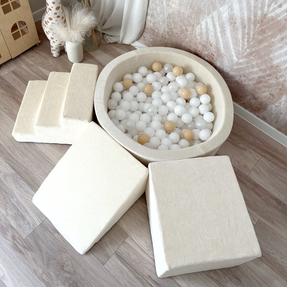 Bovenaanzicht van een ecru ballenbad met witte en beige ballen, omringd door een trapje, helling en balk.