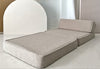 Beige bouclé lounger uitgeklapt als ligplek met een schuin rugkussen.