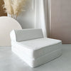 Witte bouclé lounger opgevouwen tot kinderstoel met een lage rugleuning.