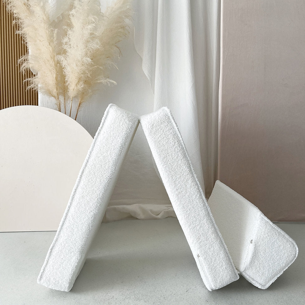 Witte bouclé lounger met de segmenten rechtop in een driehoekige opstelling.