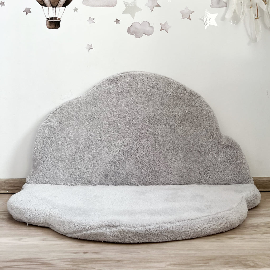 Grijze teddy speelmat Cloud met één helft tegen de muur als rugleuning voor een zitje.