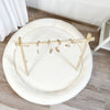 Wit teddy speelnest van bovenaf met een houten speelboog en hangend speelgoed
